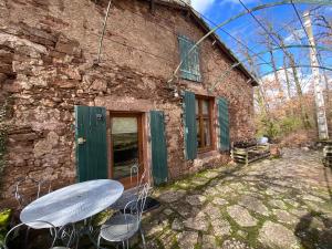 a table and chairs outside of a stone building at La cabane de Thuriès in Camarès +4 photos