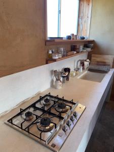 a stove top oven in a kitchen next to a counter at 泊れる図書館 さんごさん in Goto