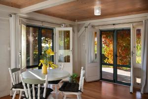 a dining room with a white table and glass doors at El Camino in Hepburn Springs