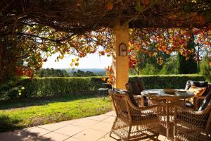 a patio with a table and chairs under a gazebo at El Camino in Hepburn Springs