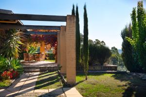 a garden with a pergola and a table and chairs at El Camino in Hepburn Springs +10 photos