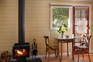 a room with a stove and a table with chairs and a window at Avalon in Hepburn Springs
