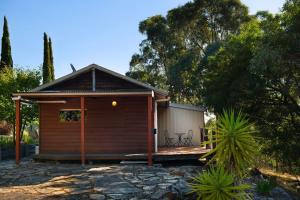 a small cabin with a porch in a garden at Avalon in Hepburn Springs