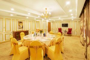 a dining room with a table and yellow chairs at Royal House Hotel 2 in Ulaanbaatar