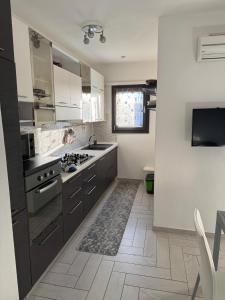 a kitchen with white cabinets and a stove top oven at Amicizia in Valledoria
