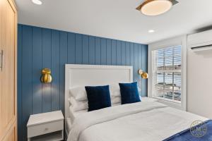 a bedroom with blue walls and a bed with blue pillows at The Mystic River Inn - Downtown in Groton