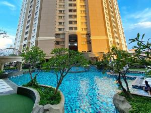 a swimming pool in front of two tall buildings at Grand Dafam Ancol Jakarta in Jakarta