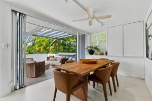 a dining room with a wooden table and chairs at Picture Point Terraces in Noosa Heads