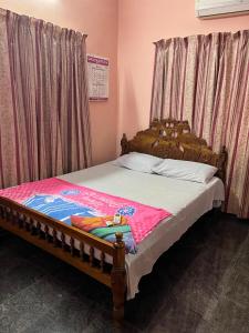a bedroom with a bed with a wooden frame at VallabhanAnnexHomestay in Varkala