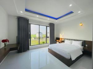 a bedroom with a bed and a large window at Hotel Trâm Anh 3 in Nhơn Trạch