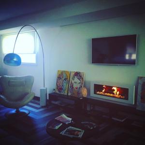 a living room with a fireplace and a chair at Residenza RoMa in Tropea