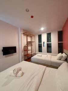 a hotel room with two beds and a television at TT Dorf Hotel Taiping in Taiping