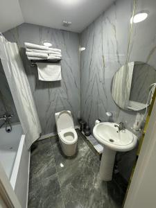 a bathroom with a white toilet and a sink at Jagalau in Balqash +17 photos
