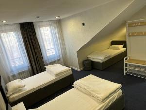 a hotel room with three beds and two windows at Jagalau in Balqash