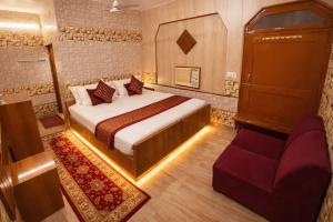 a hotel room with a bed and a couch at Tripathi's Rampath Inn Ayodhya in Ayodhya