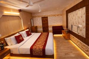 a hotel room with a bed and a chair at Tripathi's Rampath Inn Ayodhya in Ayodhya +8 photos