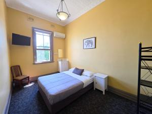 a bedroom with a bed and a window at Cessnock Hotel Hunter Valley in Cessnock