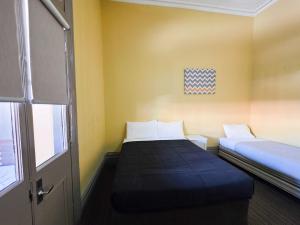 a small room with two beds and a window at Cessnock Hotel Hunter Valley in Cessnock