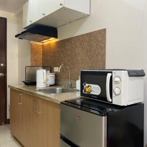 a kitchen with a microwave on top of a counter at MGs Dwell - Baguio Transient at Moldex Residences in Baguio