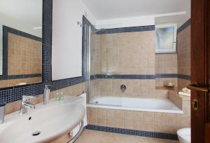 a bathroom with a tub and a sink and a toilet at Hotel Villa Ceselle in Anacapri