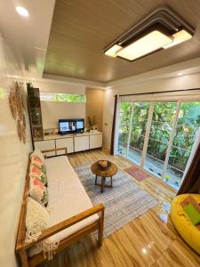a living room with a couch and a tv at KAMURAYAW SIARGAO in General Luna