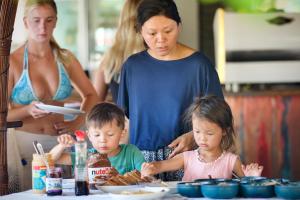 a woman and two children sitting at a table eating food at The Social - Begadang Gili Air in Gili Islands +33 photos