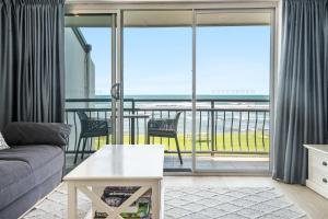 a living room with a couch and a view of the ocean at Apartment 9T in Lennox Head