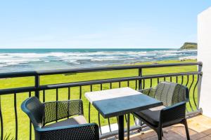 a table and chairs on a balcony overlooking the ocean at Apartment 9T in Lennox Head