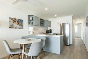 a kitchen with a table and chairs and a refrigerator at Apartment 9T in Lennox Head