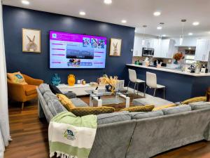 a living room with two couches and a large screen at Miramar Retreat Arcade Game Room King Bed 25 Min to Hollywood Beach in Miramar