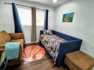 a living room with a blue couch and a basketball bed at Miramar Retreat Arcade Game Room King Bed 25 Min to Hollywood Beach in Miramar +46 photos