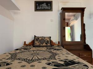 a bedroom with a bed with a pillow and a mirror at Beliya Rock View in Dambulla