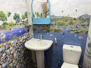 a bathroom with a sink and a toilet and a mural at Beliya Rock View in Dambulla
