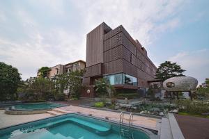 a house with a swimming pool in front of a building at The Lantern in Shunde