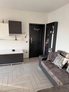 a living room with a couch and a black door at Amicizia in Valledoria