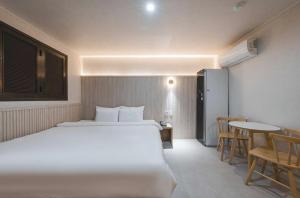 a hotel room with a bed and a table and chairs at Hotel ONYU Busan Sasang in Busan