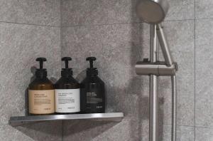 three shampoo bottles sitting on a shelf in a bathroom at Hotel ONYU Busan Sasang in Busan +24 photos