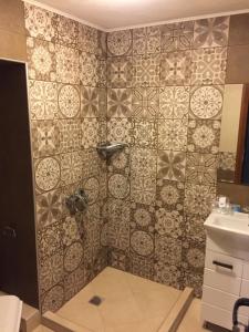 a bathroom with a shower with a tiled wall at City Garden Studio in Plovdiv +37 photos