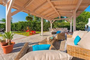 a patio with chairs and tables and a playground at Villa Giovanni in Faliraki
