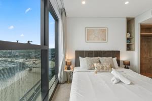 a bedroom with a white bed and a large window at 2B2B High Floor Apt with RiverView & Parking in Brisbane +70 photos