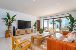 a living room with a couch and a tv at Villa Casa Luna by Villa Plus in Playa Blanca