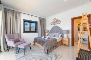 a bedroom with a bed and a ladder and a chair at Villa Casa Luna by Villa Plus in Playa Blanca +18 photos