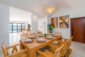 a dining room with a wooden table and chairs at Villa Casa Luna by Villa Plus in Playa Blanca