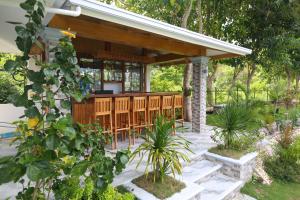 a patio with a bar in a garden at Garden Bungalows Resort in Siquijor