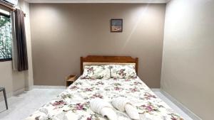 a bedroom with a bed with a floral bedspread at Collection O Southern Star Resort Pattaya in North Pattaya