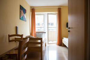 um quarto com uma cama, uma mesa e uma janela em Hostel SLEPS em Augsburg