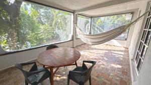 ein Zimmer mit Tisch, Stühlen und einer Hängematte in der Unterkunft Luz Sofia Bacalar in Bacalar