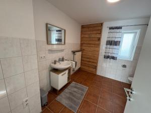 a bathroom with a sink and a mirror at Ferienwohnung Tante Betty in Essing +12 photos
