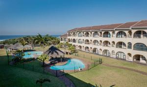 a large building with two swimming pools next to the ocean at Cabanas Del Mar 76 By Evermore in Kingsborough