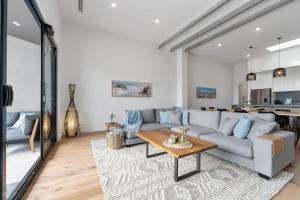 a living room with a couch and a table at Beachfront Bliss Luxury Views in Rye